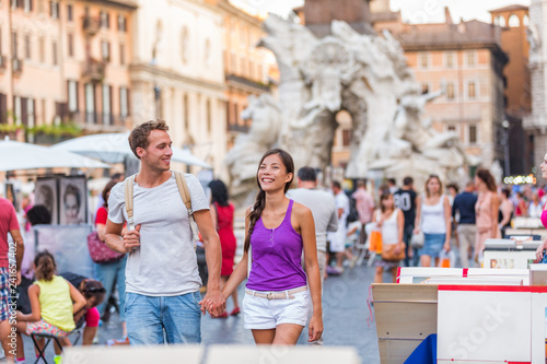 Europe travel tourists couple walking in Rome, Italy, on Piazza Navona, famous tourism attraction. Street city lifestyle, summer holidays. People relaxing enjoying life.