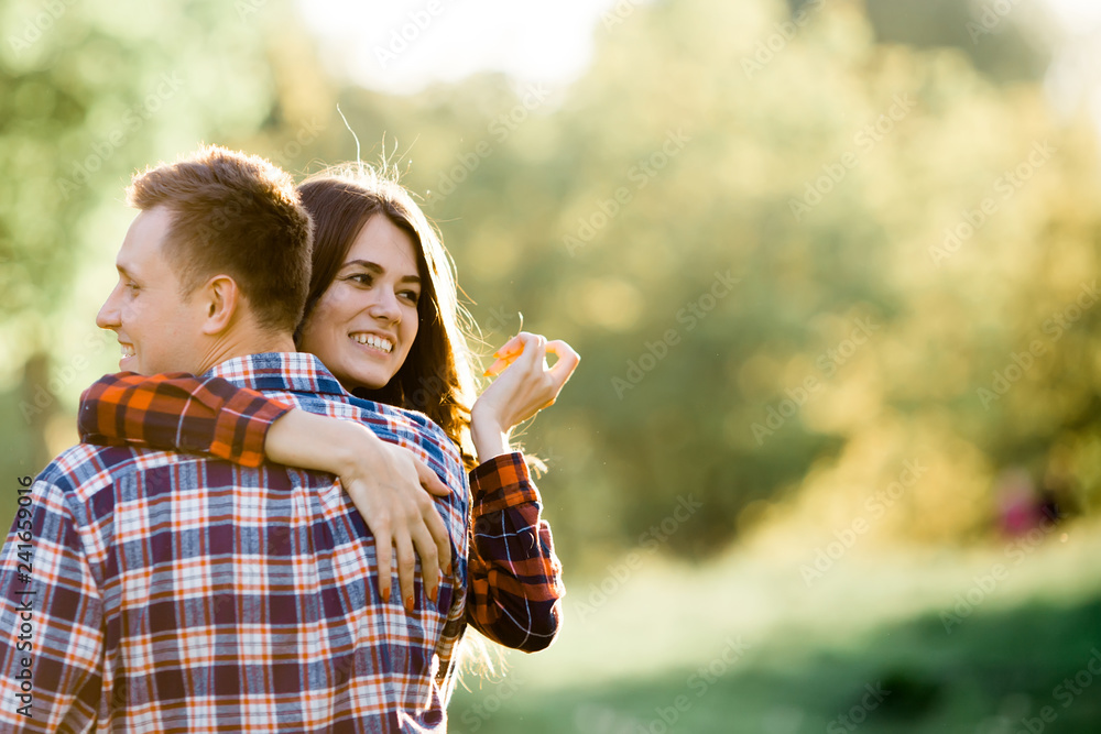 Obraz premium Couple in love. The guy is holding the girl in her arms in the park.