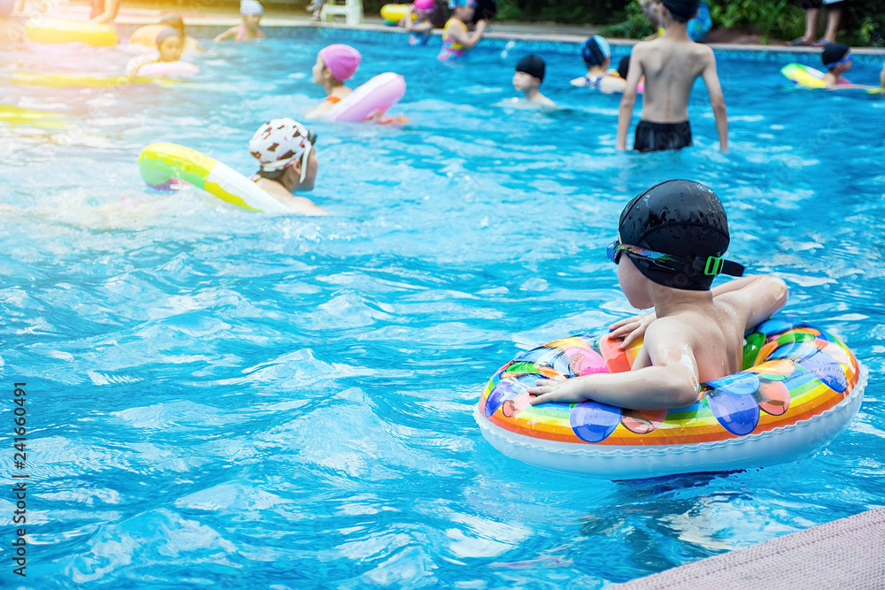 Summer children swim in the pool