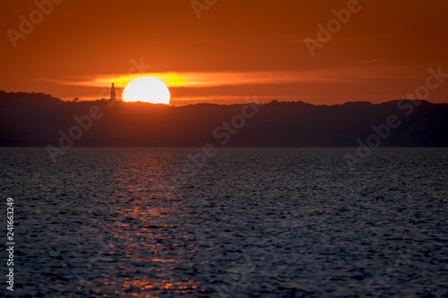 Sonnenuntergang   ber Insel Hiddensee und Leuchtturm Dornbusch