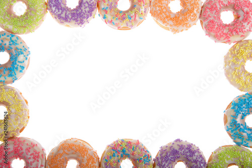 Flat lay view of many Frosted donuts with candy sprinkles arranged in a border frame isolated on white