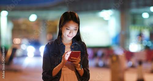 Canvas Print Woman send sms on cellphone in city street