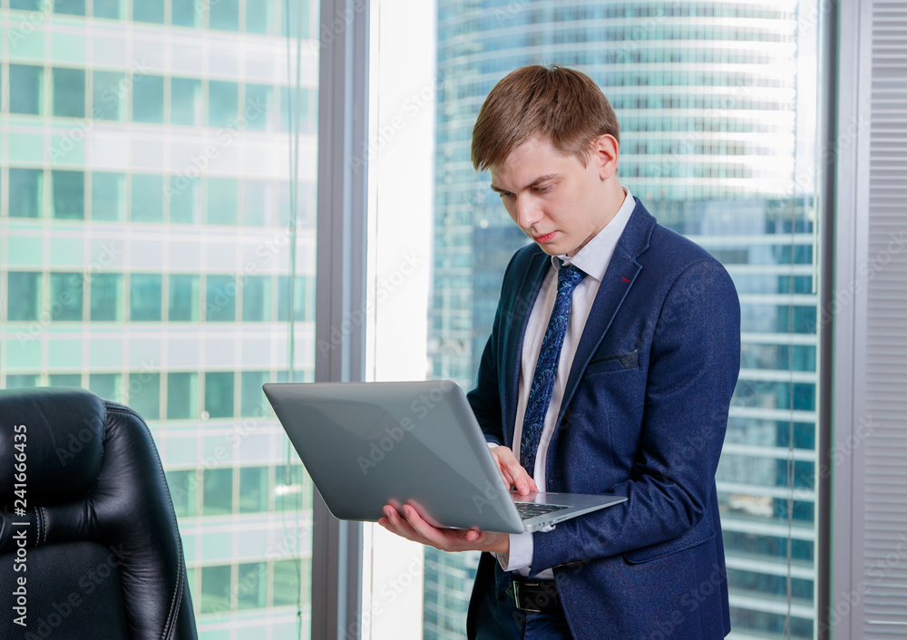 White man in office with laptop on city background. Business Technology finance concept. White man in office with laptop on city background. Business Technology finance concept.