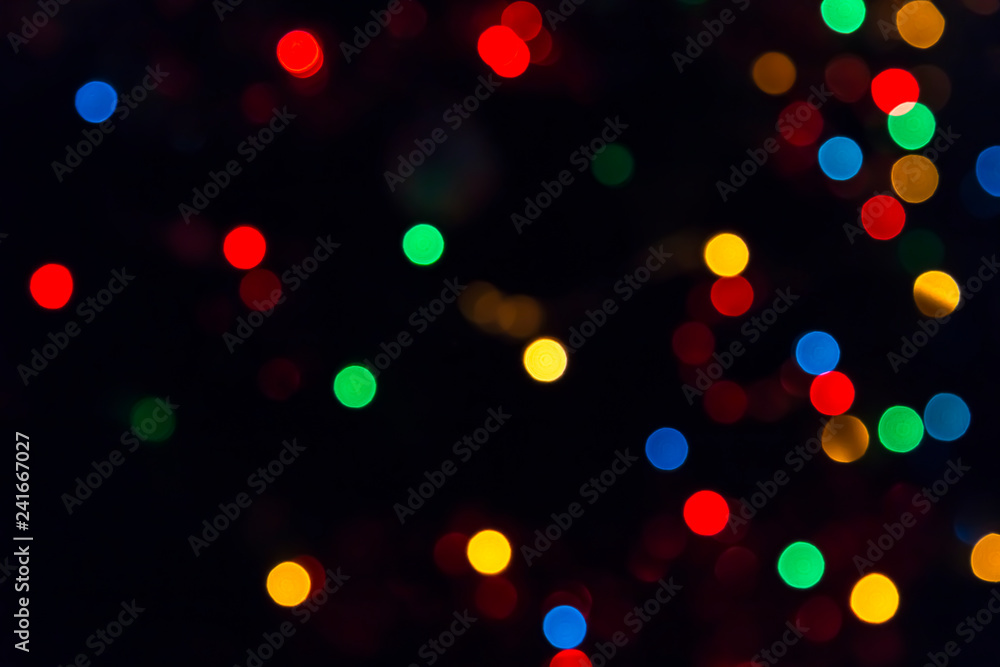 Abstract festive New Year Christmas defocused background with bokeh multicolored effect on black background with copy space.