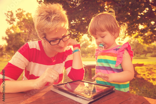 mom and her little daughter using tablet computer