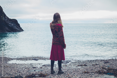 Young woman on the beach looking at the sea