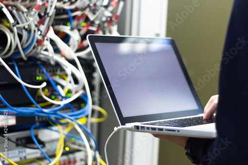 Administrator working in data center configure and check internet network on computer laptop ,Hands typing text on a laptop keyboard , Selective focus