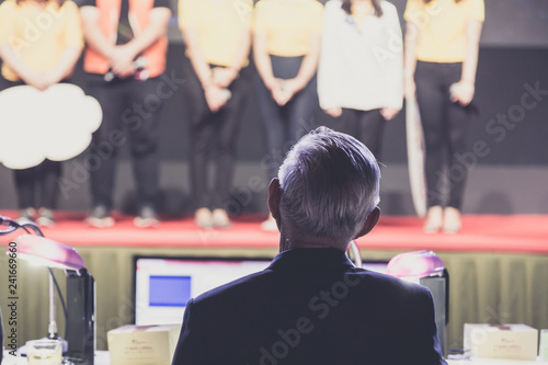 Speaker giving a talk on corporate Business Conference hall or seminar room background.