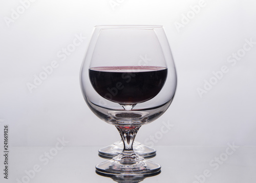 isolate two drinking glass with red wine one after the other on black background