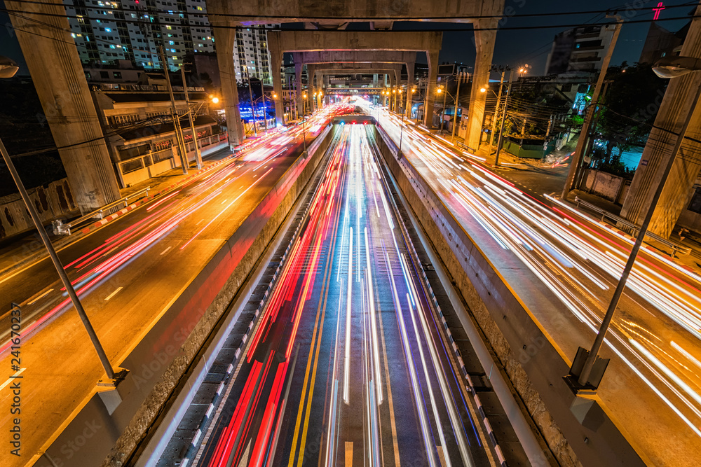 Long exposure of traffic jam with underground tunnel in rush hour at night time in Bangkok, transportation with cityscape concept