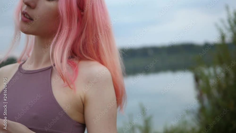Beautiful pink haired model posing in swimsuit at sunset Beautiful pink haired model posing in swimsuit at sunset