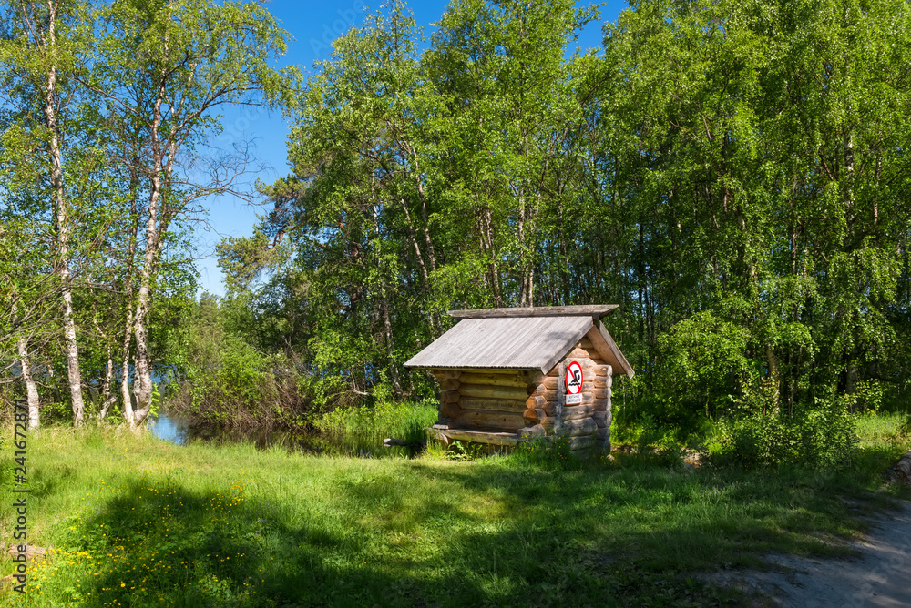 SOLOVKI, REPUBLIC OF KARELIA, RUSSIA - JUNE 25, 2018:A small wooden house stands on the shore of a forest lake above the river on Solovki Island. Solovetsky archipelago, Arkhangelsk Region, Russia SOLOVKI, REPUBLIC OF KARELIA, RUSSIA - JUNE 25, 2018:A small wooden house stands on the shore of a forest lake above the river on Solovki Island. Solovetsky archipelago, Arkhangelsk Region, Russia