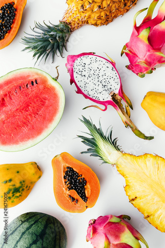 Fotografi Flat lay tropical fruit layout made of dragon fruit, watermelon, papaya and pineapple