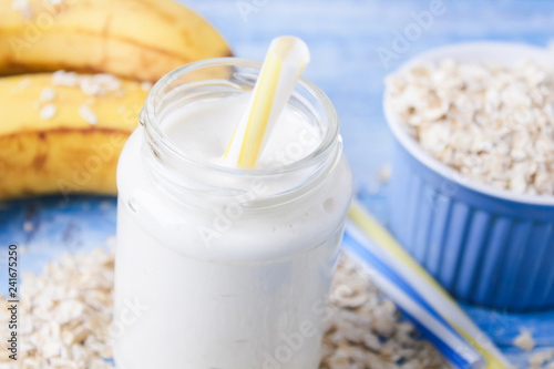 Banana smoothie with honey and oats on a wooden table.