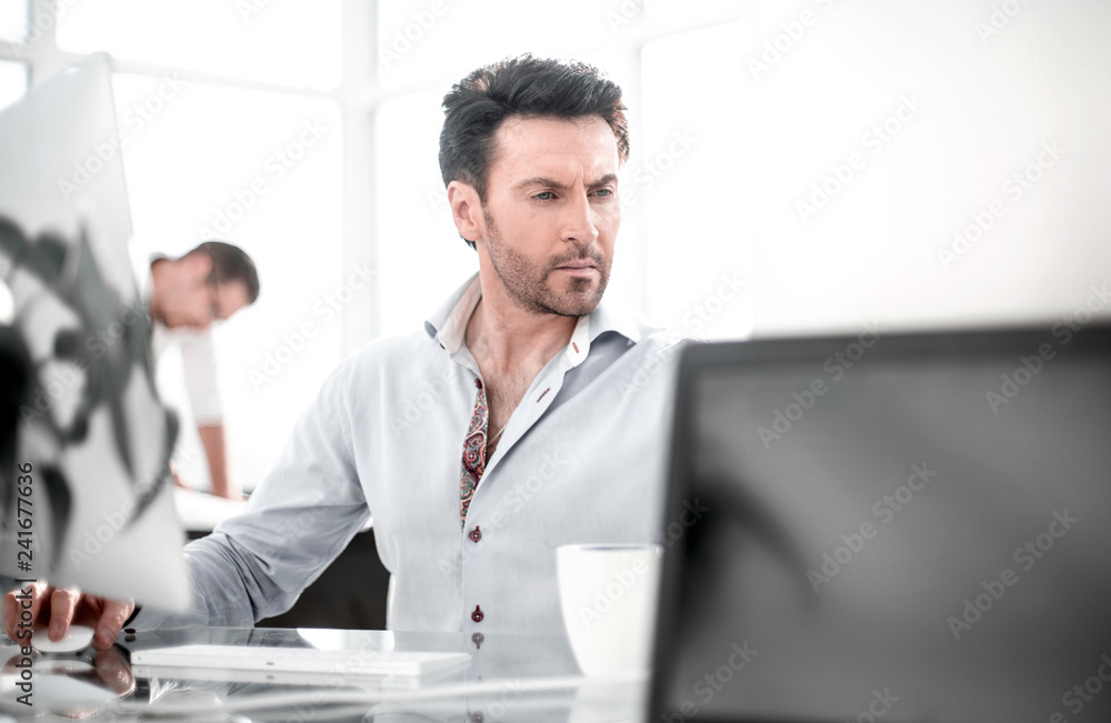 business man talking to a colleague sitting at his Desk business man talking to a colleague sitting at his Desk