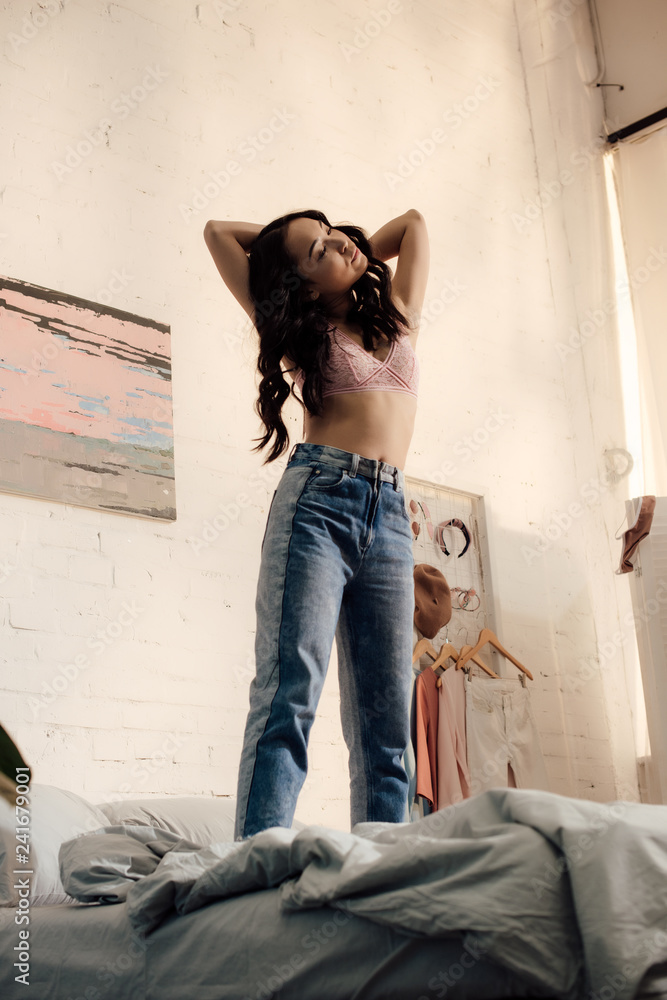 beautiful young asian woman in pink bra and jeans standing on bed Stock  Photo | Adobe Stock