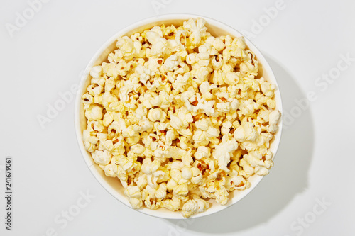Full of popcorn in bowl on white background