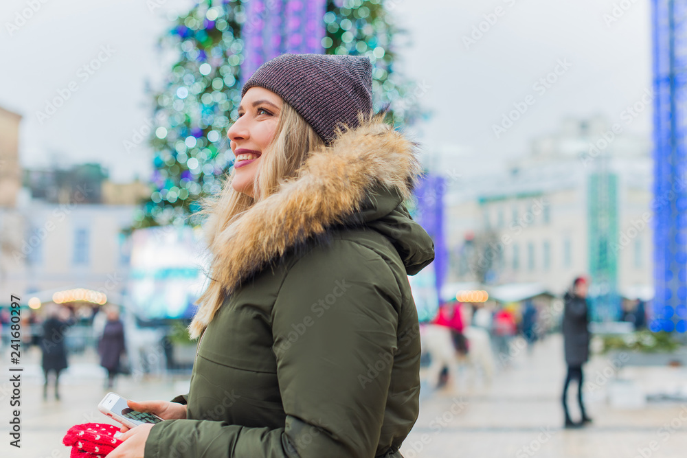 Portrait of attractive happy plus size young model in parka jacket casual style walk at city at winter day . Life of xl woman  