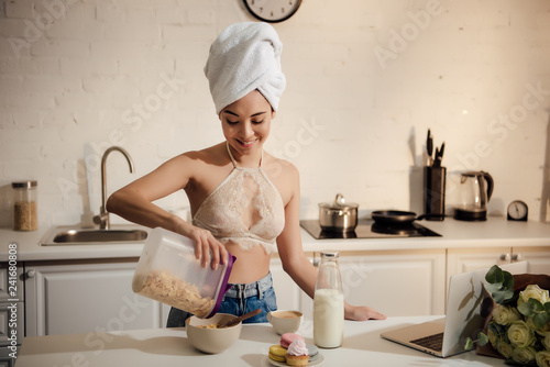 Wallpaper Mural beautiful smiling young woman holding container with corn flakes for breakfast Torontodigital.ca