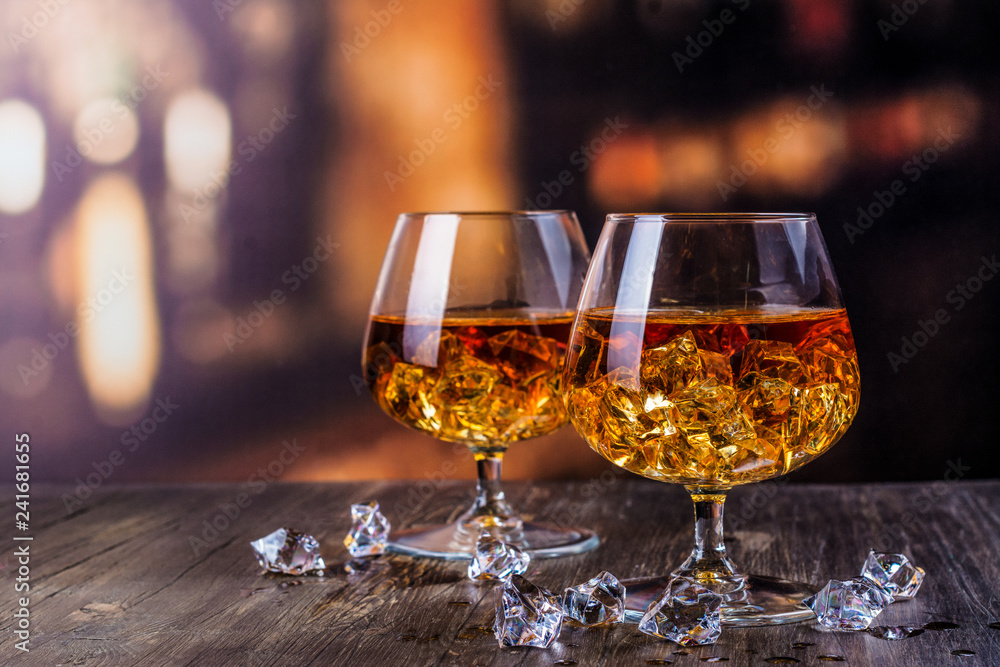 Two glasses of Cognac with ice cubes Two glasses of Cognac with ice cubes