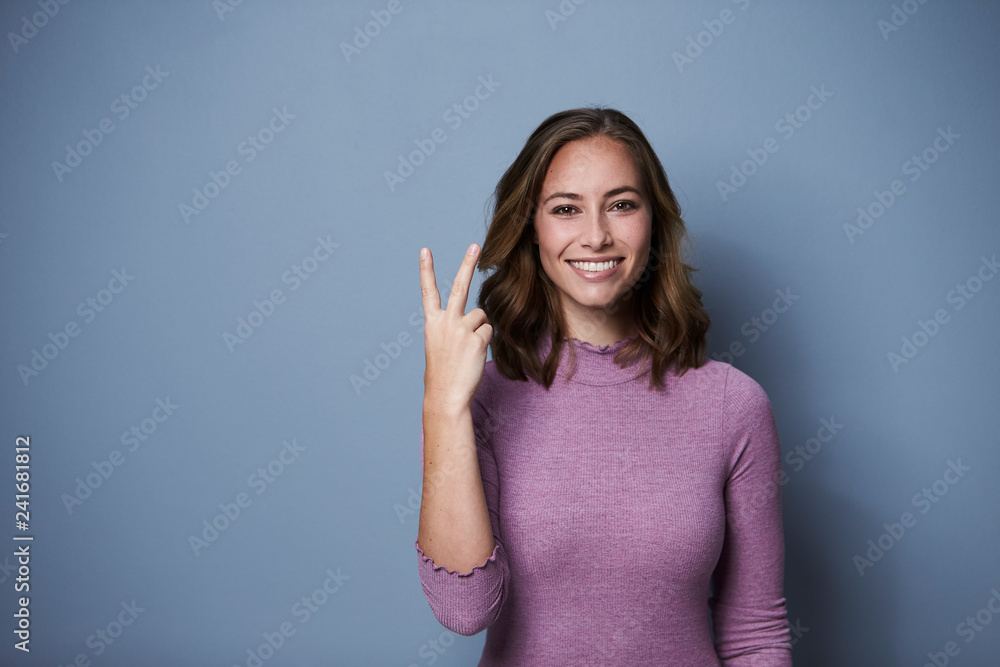 Beautiful woman using fingers to show two, studio Beautiful woman using fingers to show two, studio