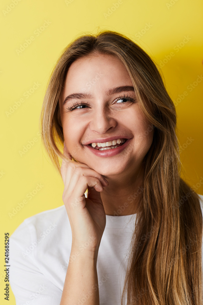 Laughing young lady against yellow background Laughing young lady against yellow background
