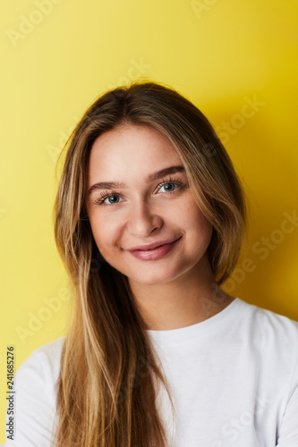 Smiling young woman against yellow bacvkground