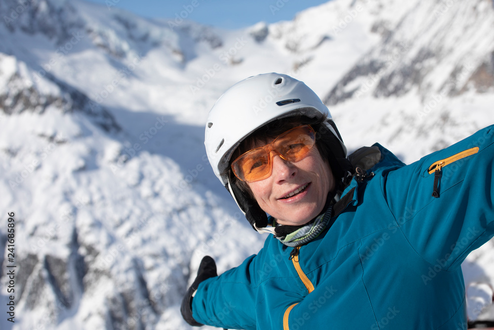 Senior Skifahrerin mit Helm und Brille auf der Skipiste