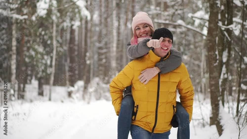 happy loving couple walking in snowy winter forest, spending christmas vacation together. Outdoor seasonal activities. Lifestyle capture. happy loving couple walking in snowy winter forest, spending christmas vacation together. Outdoor seasonal activities. Lifestyle capture.