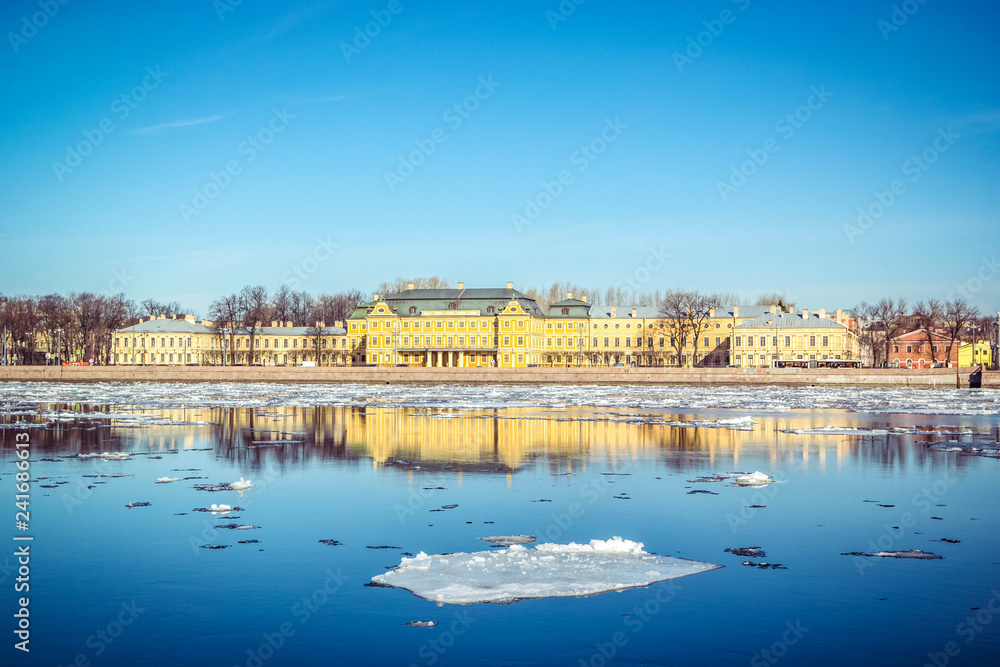 Fototapeta premium St. Petersburg granite embankment, panoramic view from Neva River on cityscape and architecture of city, spring ice drift, Saint Petersburg, Russia.