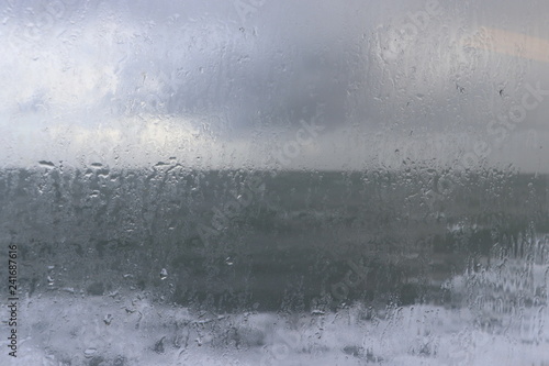 Rainy window with waves in the background