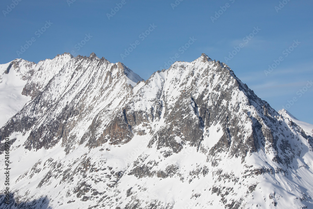 verschneite Bergspitze in der Sonne Bergfels