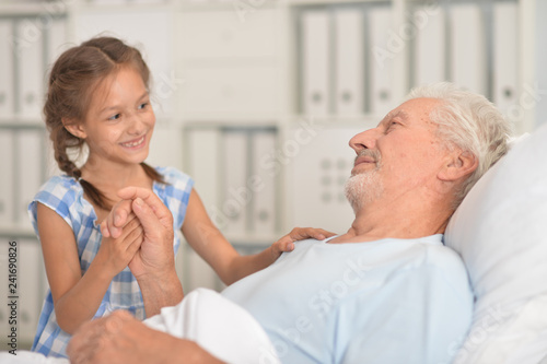 Portrait of cute girl visiting sick grandgfather © aletia2011