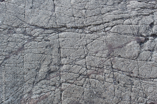 Scratched surface of a large flat grey rock abstract