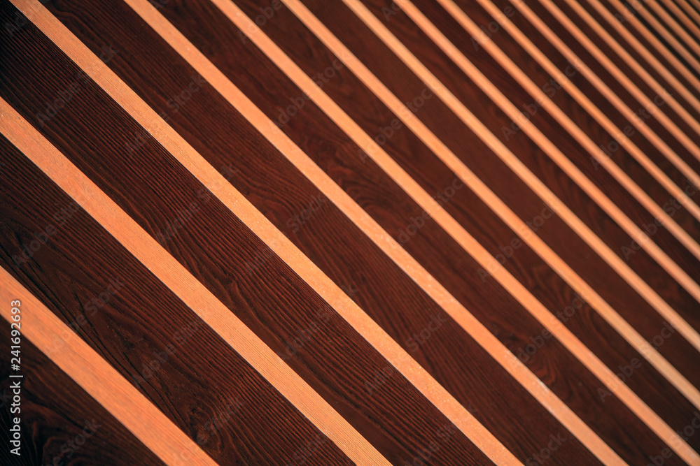 Background of wooden planks arranged diagonally, Diagonal boards with light incidence. Format-filling view of diagonally arranged wooden planks with uniform gaps and rear light incidence