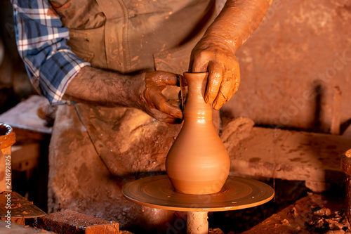 Professional potter making bowl in pottery workshop, studio.