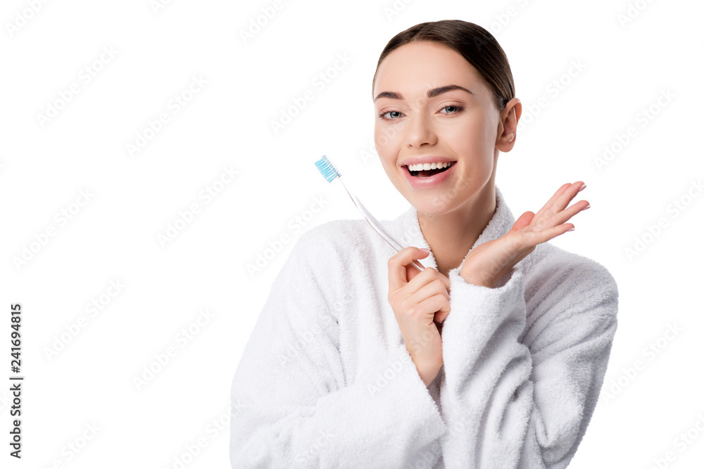 cheerful woman in white bathrobe holding toothbrush and looking at camera isolated on white cheerful woman in white bathrobe holding toothbrush and looking at camera isolated on white