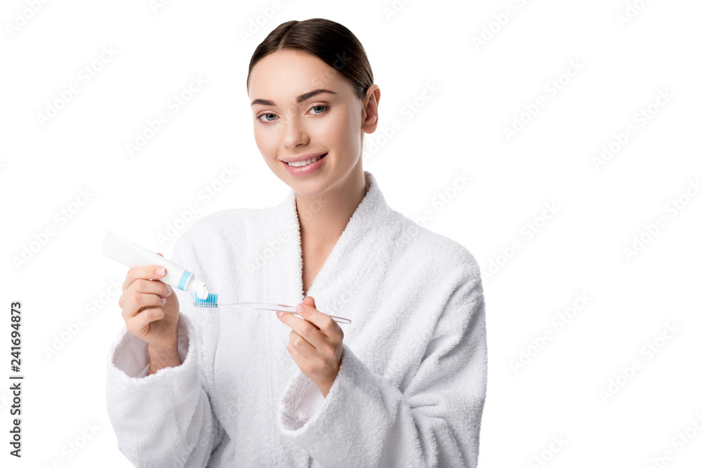 smiling woman in white bathrobe putting toothpaste on toothbrush isolated on white smiling woman in white bathrobe putting toothpaste on toothbrush isolated on white