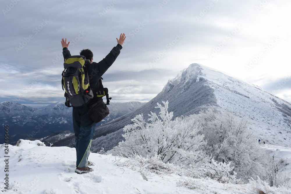 Hiker in a winter mountains. Concept of healthy lifestyle and successful climb, hiking in nature. Winter background Hiker in a winter mountains. Concept of healthy lifestyle and successful climb, hiking in nature. Winter background