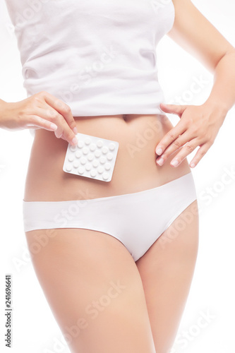 Stomach or menstrual pain. Woman with pains in abdomen. Female belly and hands holding pill package.