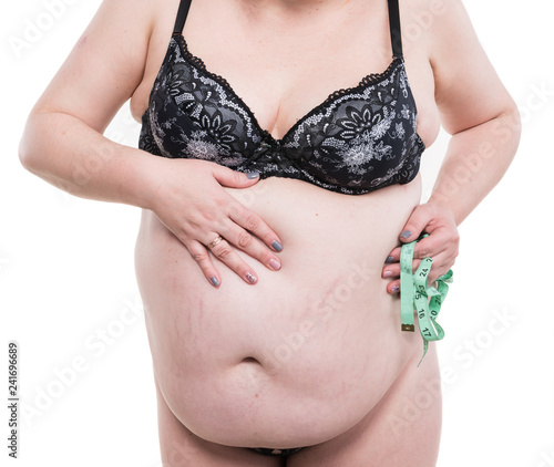 Overweight woman posing with measure tape on a white background photo