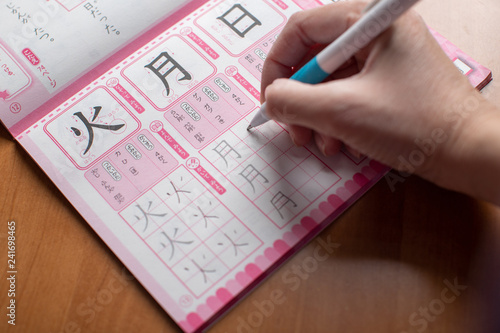 Learning and practice: workbook / notebook with a lot of chinese and japanese language characters (kanji) (translation - fire, moon and sun), hand writing with pen