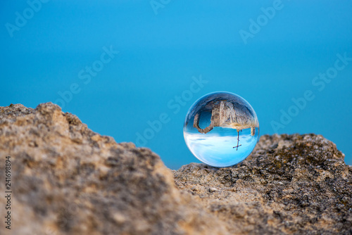  Upside down seascape with the chapel of St. Nicholas at Cape Kaliakra - reflection in a lens ball - selective focus, space for text