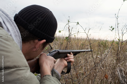 Hunter With Old Hunting Riffle Waiting for Pray in the Woods