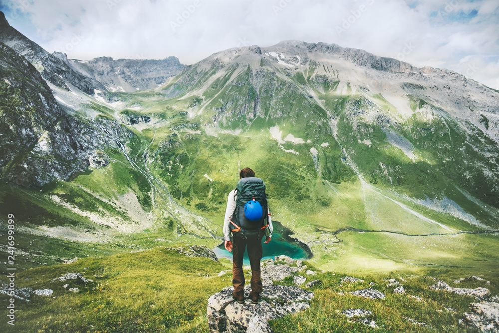 Traveler man hiking alone in mountains adventure active lifestyle traveling  summer vacations outdoor solitude harmony with nature hiker standing on cliff above lake landscape - obrazy, fototapety, plakaty 