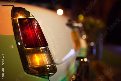 old car headlamp with night lights illuminated by street lights