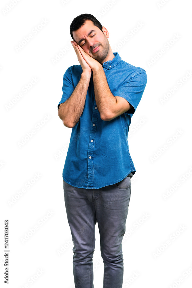 Handsome man with blue shirt making sleep gesture Handsome man with blue shirt making sleep gesture
