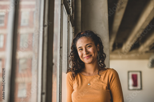 Portrait of smiling woman standing by window