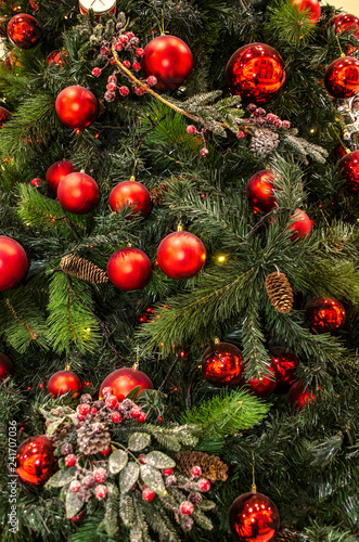 Christmas background with cones and red balls, with red berries on a twig, glowing garlands on pine branches