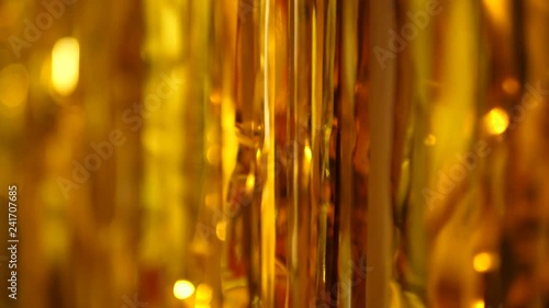 festive long golden tinsel gleams in the light